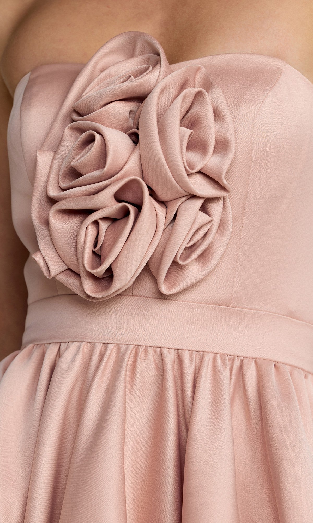 Close-up of the Mac Duggal 27554 High-Low Formal Dress in blush pink, featuring a strapless design with fabric roses adorning the bodice and a gathered skirt.
